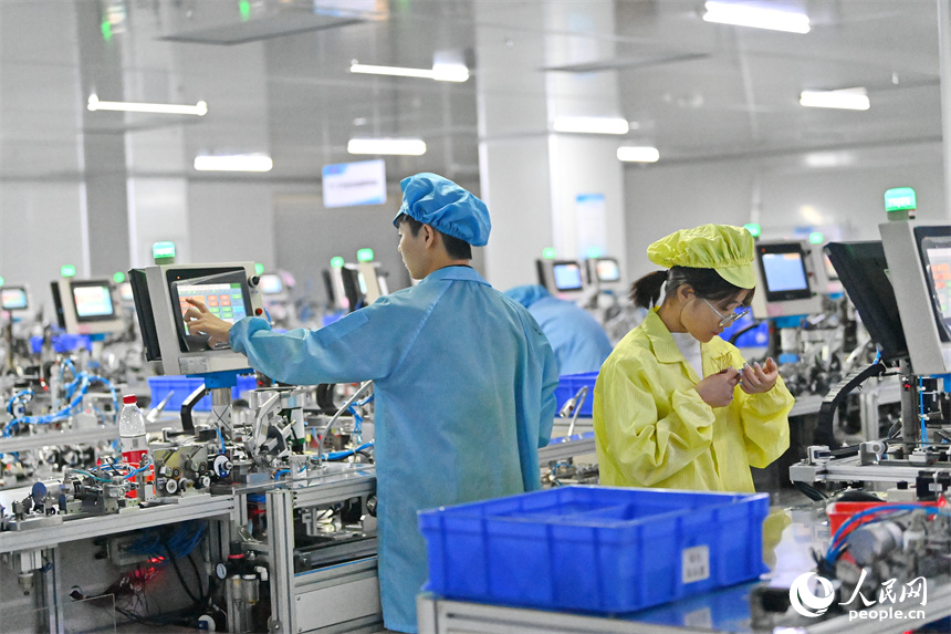 工作人員在全自動穿環機生產磁性元器件。人民網 朱海鵬攝