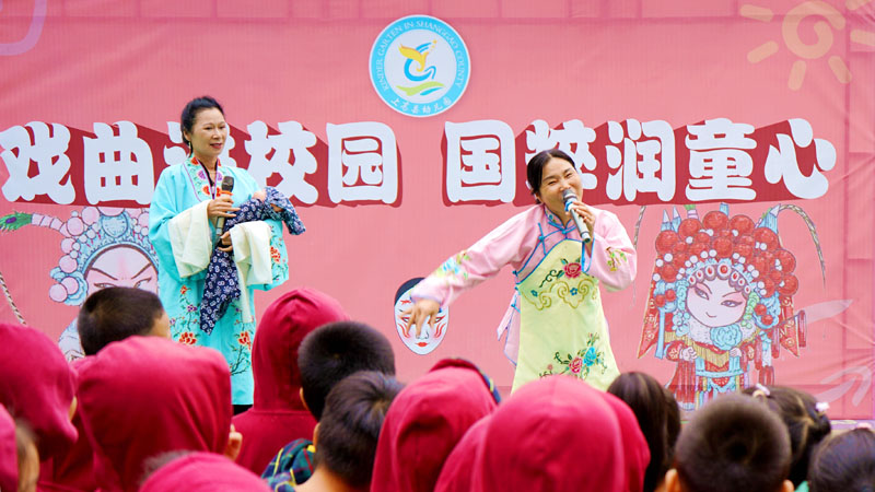 孩子们在观看县文化馆采茶戏老师的表演。陈旗海摄