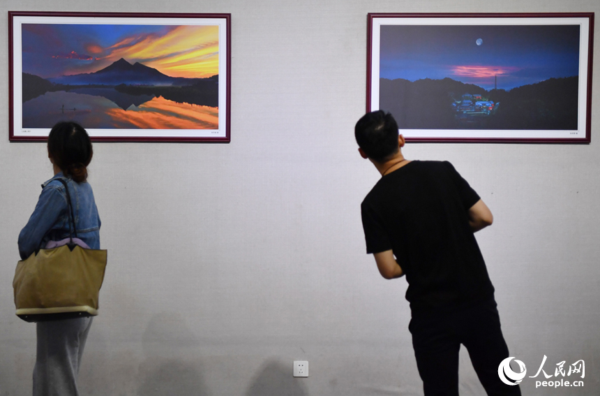 参观者们正在欣赏展厅内的“山水武宁”精美图片。 人民网记者 时雨摄