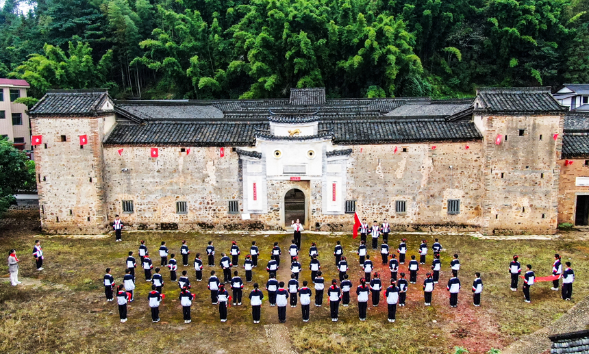 定南县第一小学在该县第一名共产党员方学元故居虎形围举行庆祝建队日活动。钟杰摄