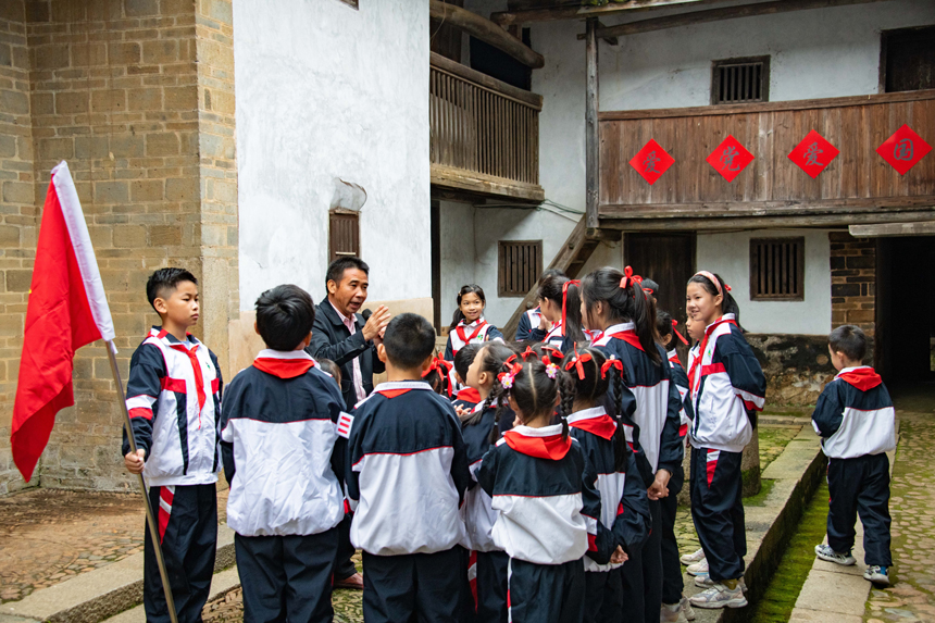 定南县第一小学在该县第一名共产党员方学元故居虎形围举行庆祝建队日活动。钟杰摄