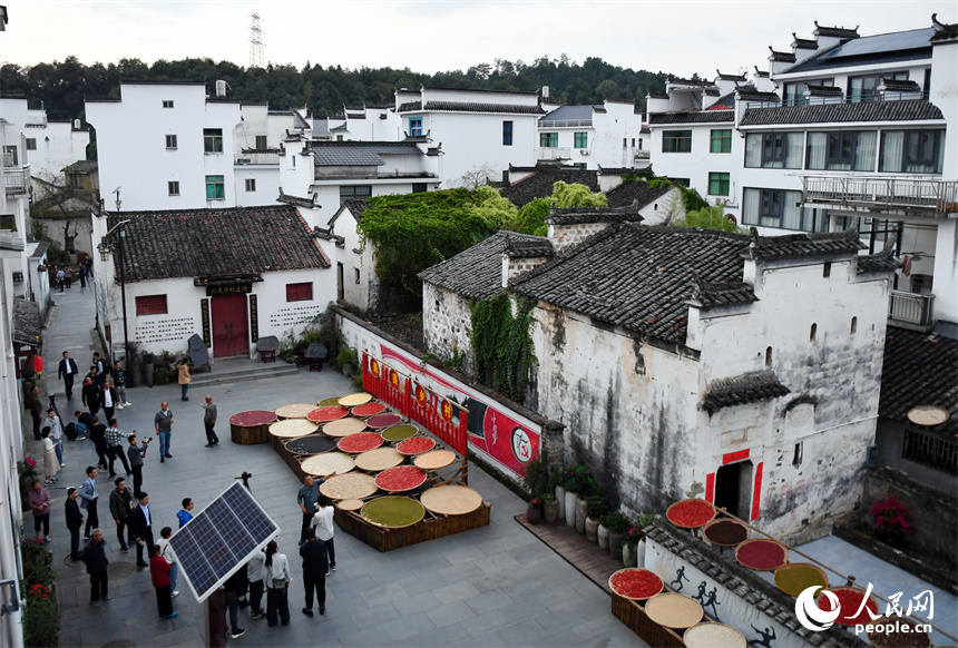 婺源县秋口镇王村石门自然村，游客们在晒场上观赏晒秋美景。 人民网记者 时雨摄