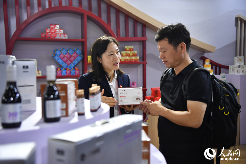 參展商向客商介紹展出的醫藥產品。 人民網記者 時雨攝