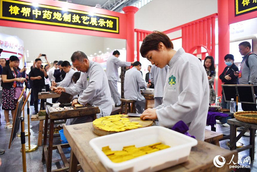 樟幫中藥炮制技藝展演現場，藥工們正在進行各類中藥材的炮制。 人民網記者 時雨攝