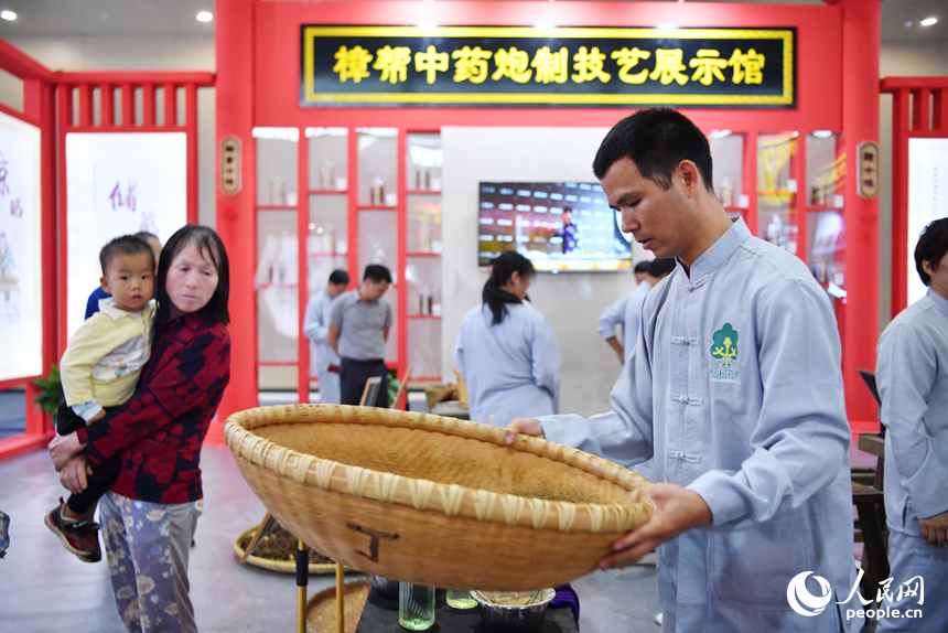 樟幫中藥炮制技藝展演現場，藥工們正在進行各類中藥材的炮制。 人民網記者 時雨攝