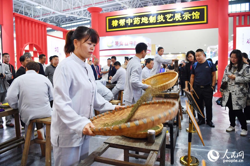 樟幫中藥炮制技藝展演現場，藥工們正在進行各類中藥材的炮制。 人民網記者 時雨攝