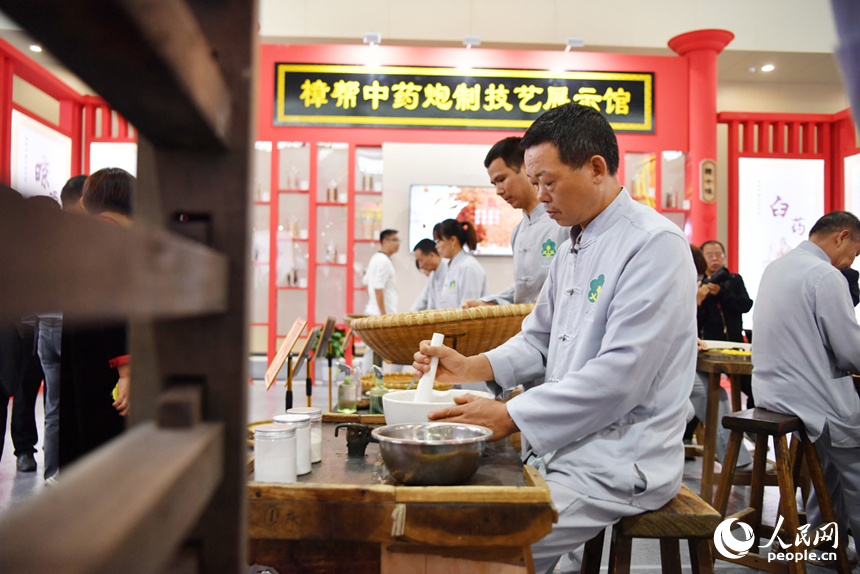 樟幫中藥炮制技藝展演現場，藥工們正在進行各類中藥材的炮制。 人民網記者 時雨攝