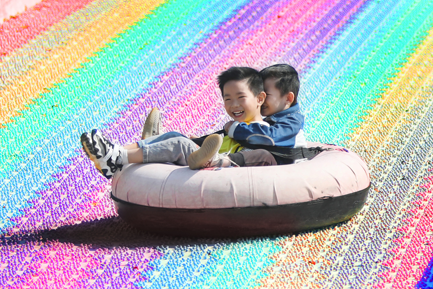 10月24日，江西省宜春市上高縣野市鄉中心幼兒園的孩子們迎著秋日驕陽暢滑彩虹滑道。陳旗海攝