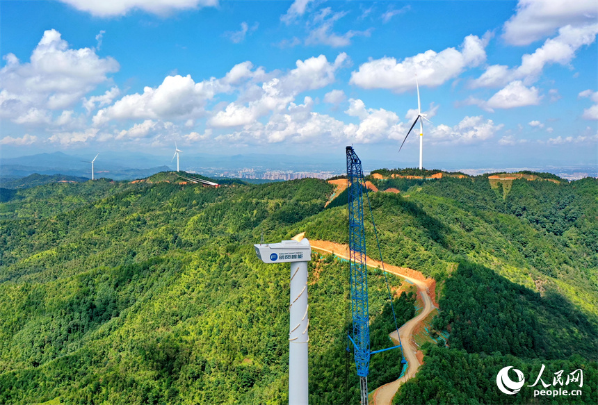 在南康區清田風電場二期項目施工現場，工人在吊裝風力發電機組設備。人民網 朱海鵬攝