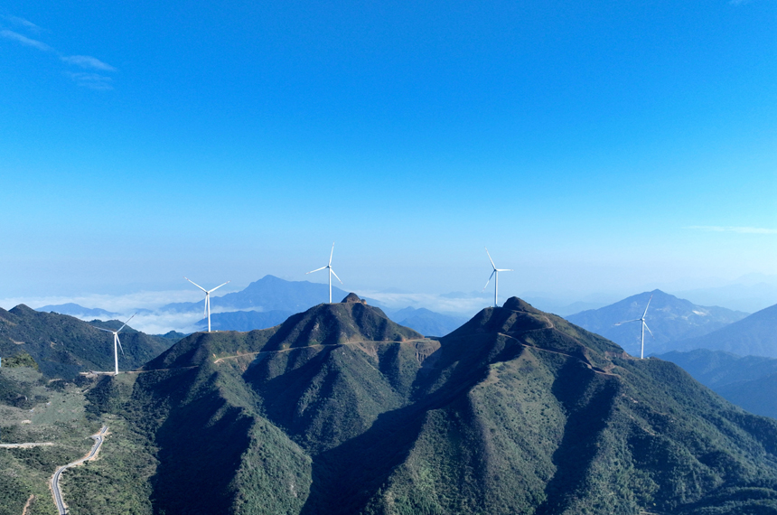 一座座風力發電機組與連綿的青山構成了一幅美麗的生態畫卷。李建平攝