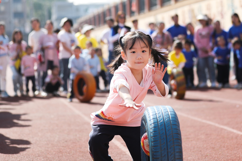 孩子們正在參加輪胎滾滾游戲。陳旗海攝