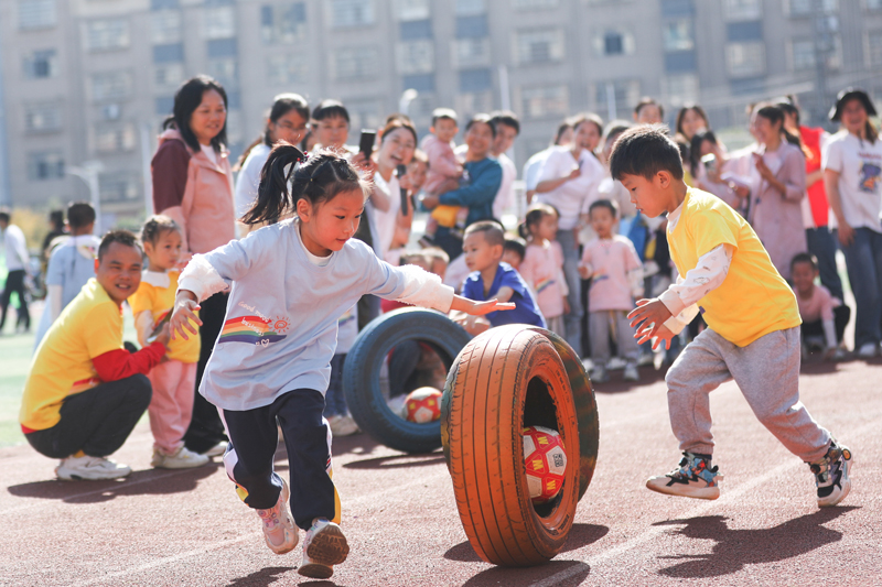 孩子們正在參加輪胎滾滾游戲。陳旗海攝