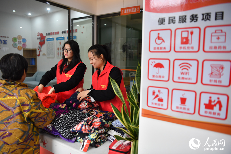 南丰县琴台路社区的志愿者正在为居民免费分发衣物。 人民网记者 时雨摄
