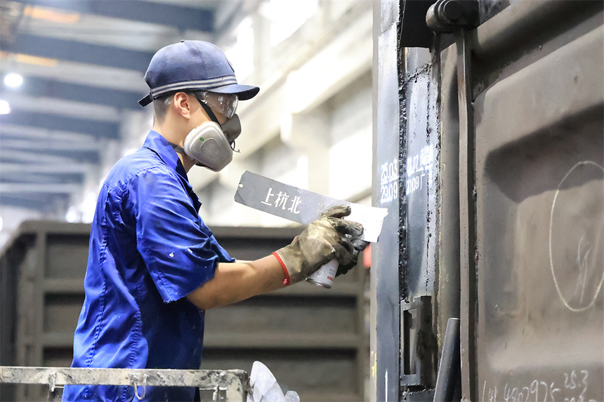 南昌南車輛段向塘修車車間綜合組職工正在涂打車輛檢修單位標記。 陳鬆攝