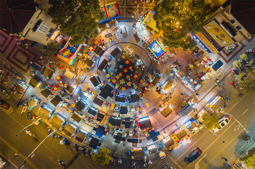 航拍视角向下看，夜市灯火通明。