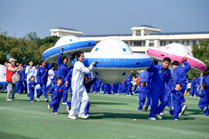 家长和幼儿一起托举飞碟，向太空出发。刘兆春摄
