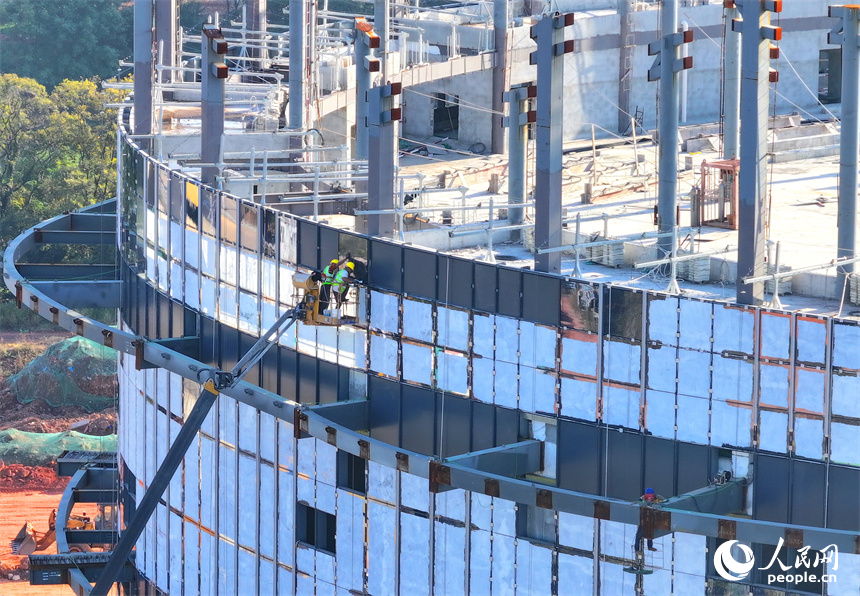 工人在安装建筑外立面玻璃幕墙。人民网 朱海鹏摄