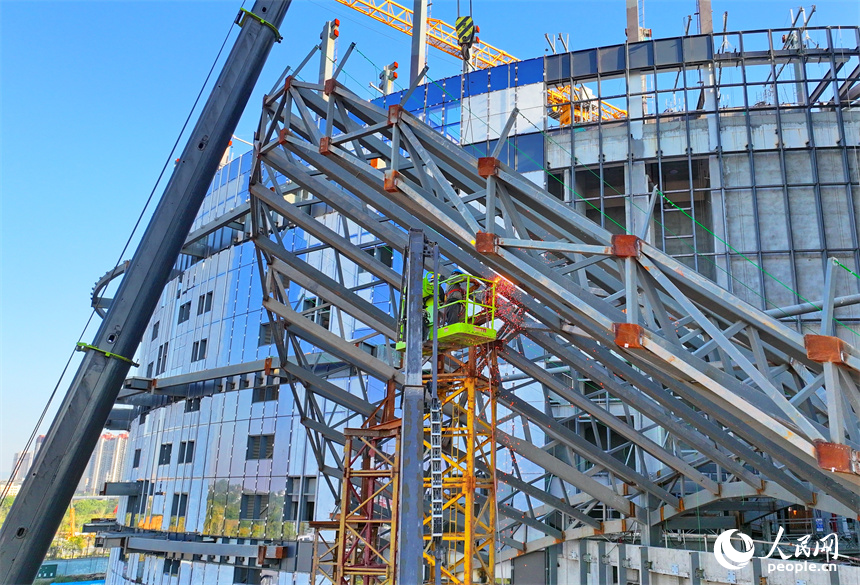 工人在安装焊接建筑外立面钢架棚。人民网 朱海鹏摄