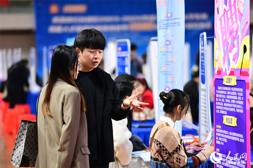 毕业生在招聘会了解咨询招聘信息，与招聘单位、企业负责人进行一对一洽谈沟通。人民网 朱海鹏摄