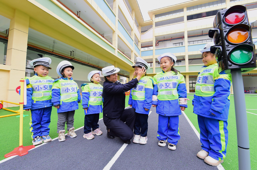民辅警走进该县第三幼儿园，帮助孩子们掌握交通安全常识，提高交通安全意识。吕春华摄