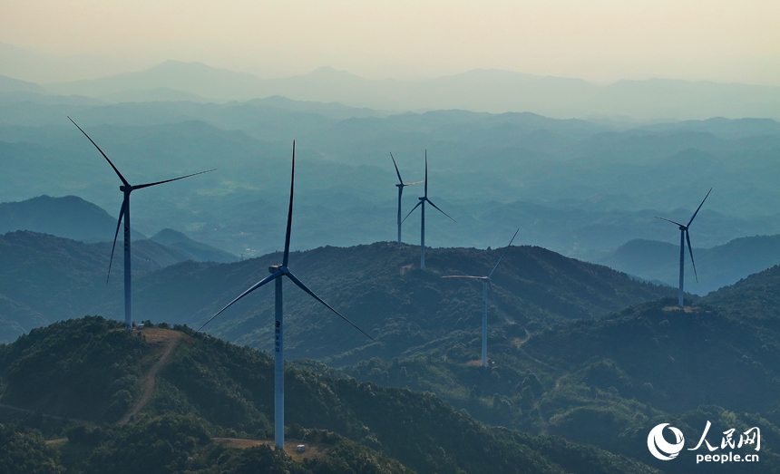 贛州市定南縣歷市鎮群山之上，風力發電機迎風旋轉，轉化為清潔電源並入電網輸往工廠企業、千家萬戶。人民網 朱海鵬攝