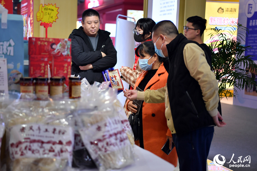 參展商正在向顧客介紹米粉產品。 人民網記者 時雨攝