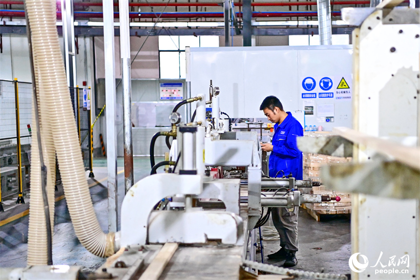 一名工人在中国移动5G物联网示范车间忙碌，智能化生产线降低了企业用工成本。人民网 朱海鹏摄