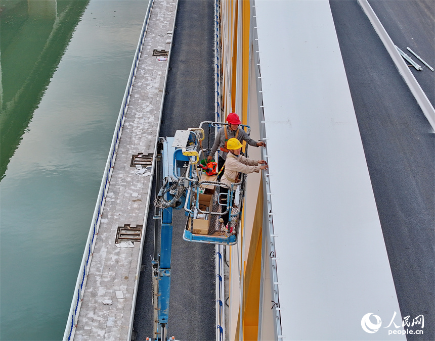 贛州市螺溪洲大橋項目建設地，工人在安裝橋梁照明設施，整橋進入施工收尾期。人民網 朱海鵬攝