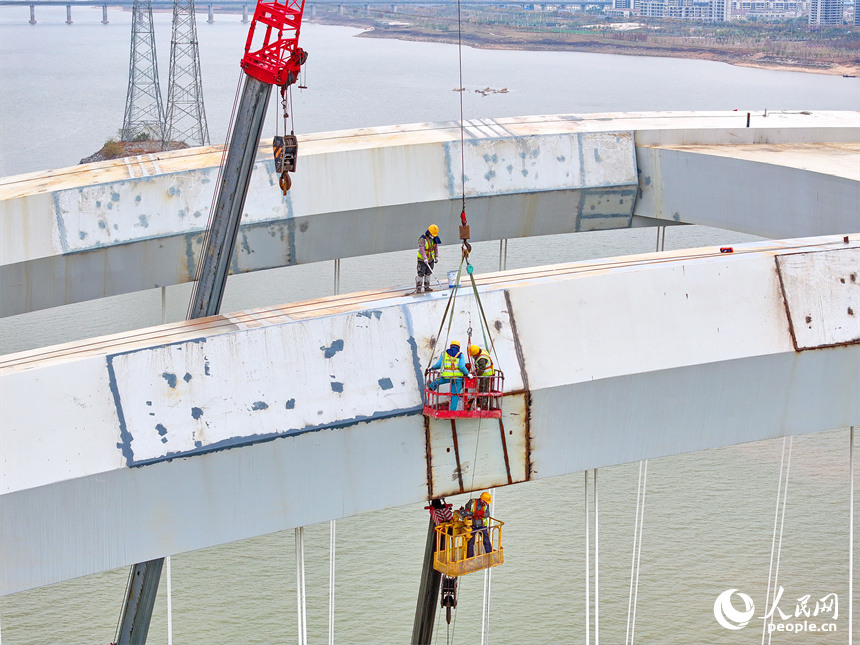 南昌市復興大橋項目建設工地，起重機吊臂林立，工人在加緊進行橋梁防鏽“換裝”作業。人民網 朱海鵬攝