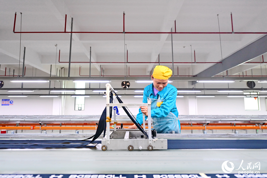 紡織工人在生產線上加工出口國外的服飾織帶產品。人民網 朱海鵬攝