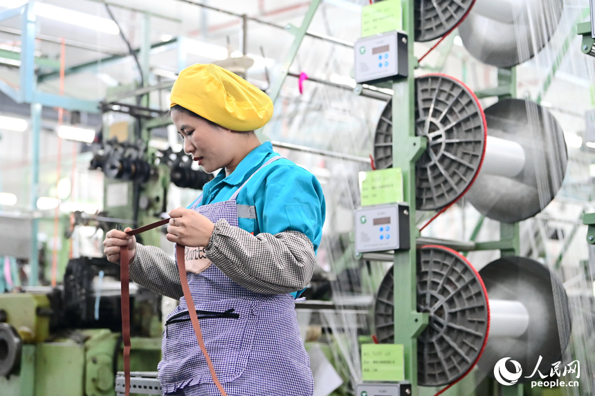 紡織工人在生產線上加工出口國外的服飾織帶產品。人民網 朱海鵬攝