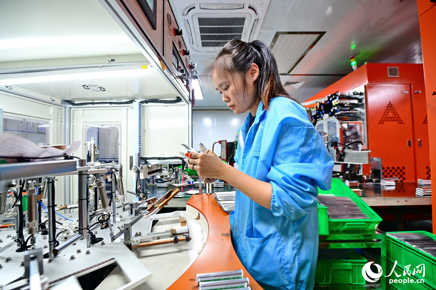 信丰县5G产业园的赣州拓远新能源有限公司生产车间内，员工在生产聚合物锂离子蓄电池。人民网 朱海鹏摄
