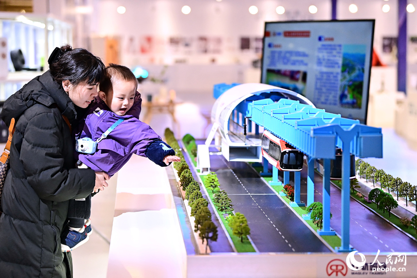 江西省赣州市南康区家居美学馆，参展观众在观看第三届江西设计周工业设计类“红轨”永磁磁浮轨道交通系统展品。人民网 朱海鹏摄