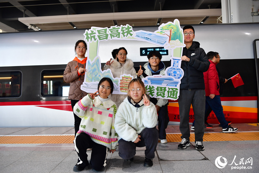 旅客们在动车组前拍照留念。 人民网记者 时雨摄