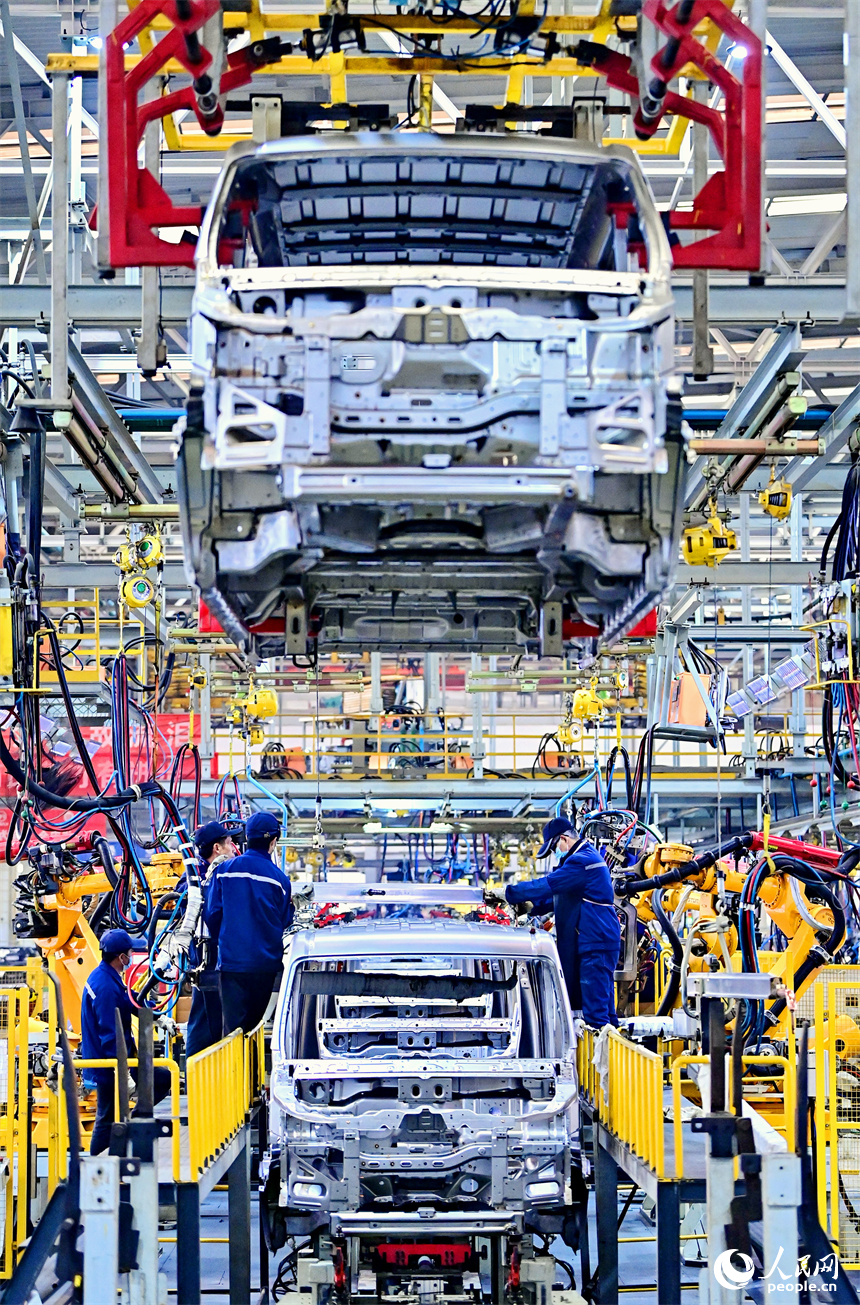 在贛州市經濟技術開發區的一家新能源汽車制造公司，員工在焊接組裝新能源電動汽車車架。人民網 朱海鵬攝