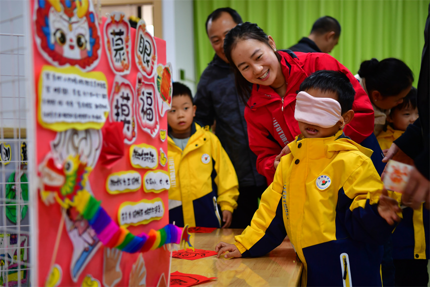 幼儿参加“蒙眼摸福”的趣味游戏。时雨摄