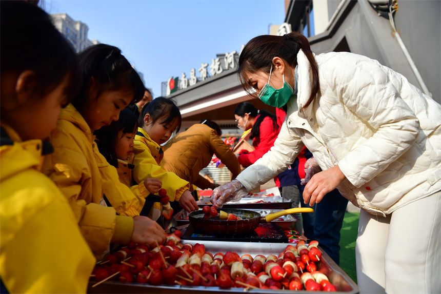 老师和幼儿们共同制作糖葫芦。时雨摄