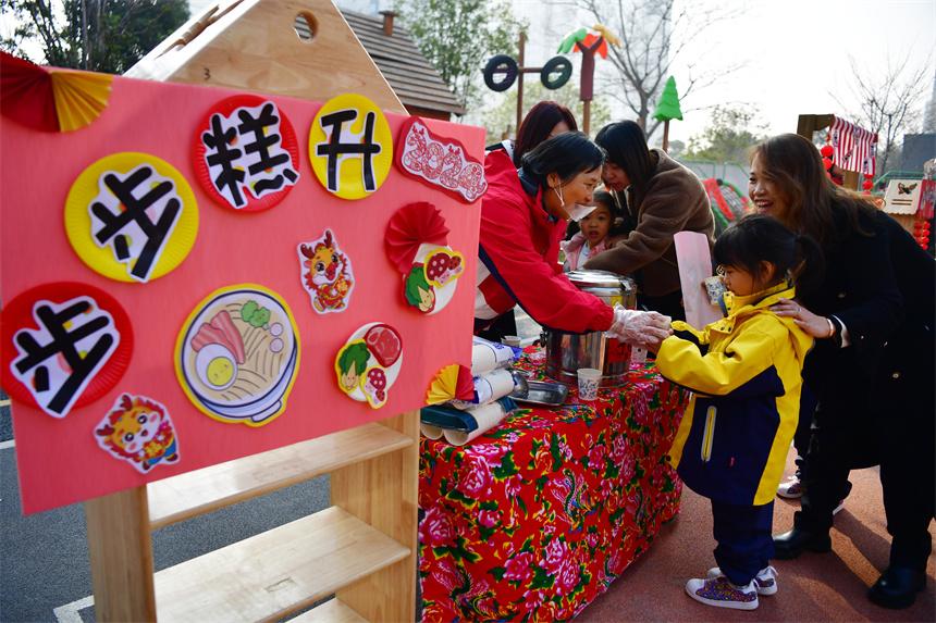老師在“廟會集市”向幼兒們分發美食。時雨攝