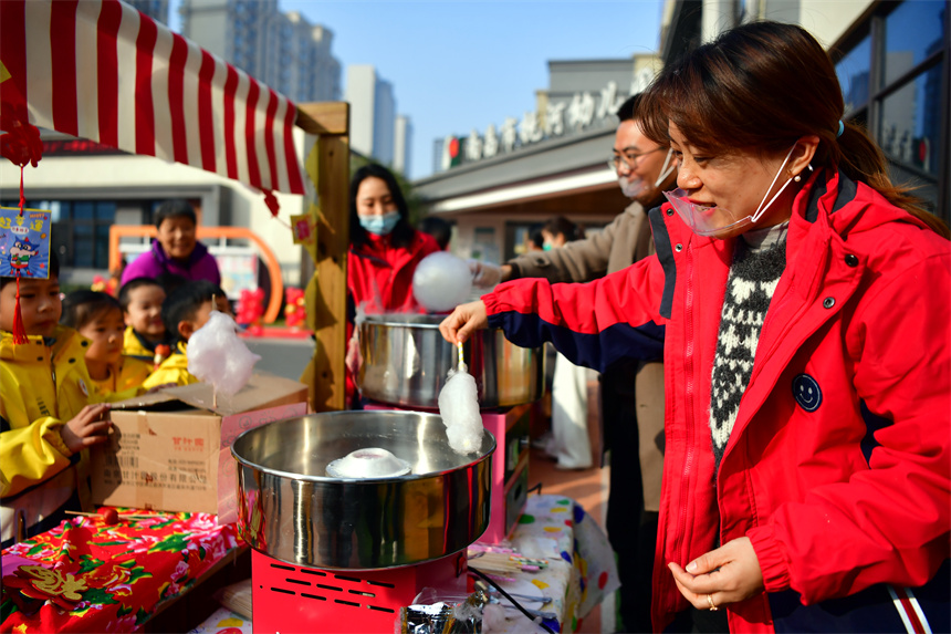 老師們在“廟會集市”上給幼兒們做棉花糖。時雨攝