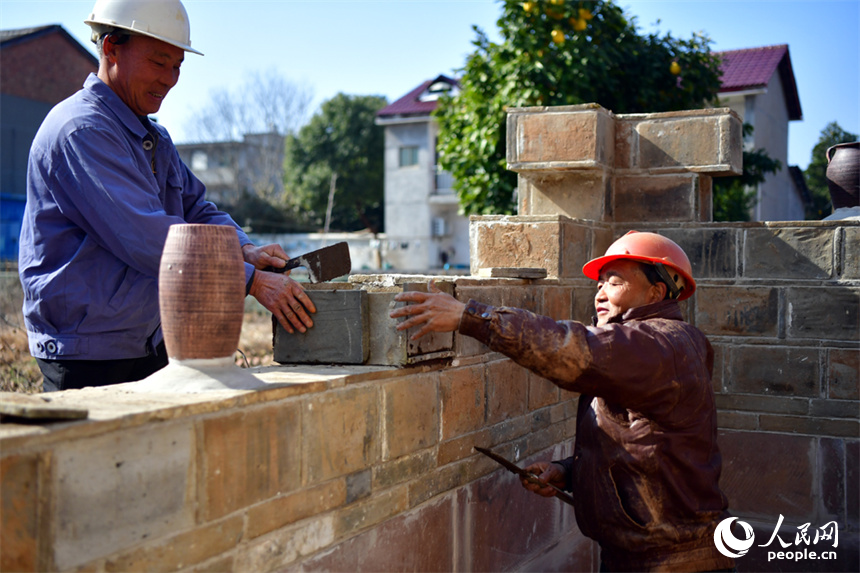 建筑工人正在修繕吳氏家廟的院牆。 人民網記者 時雨攝