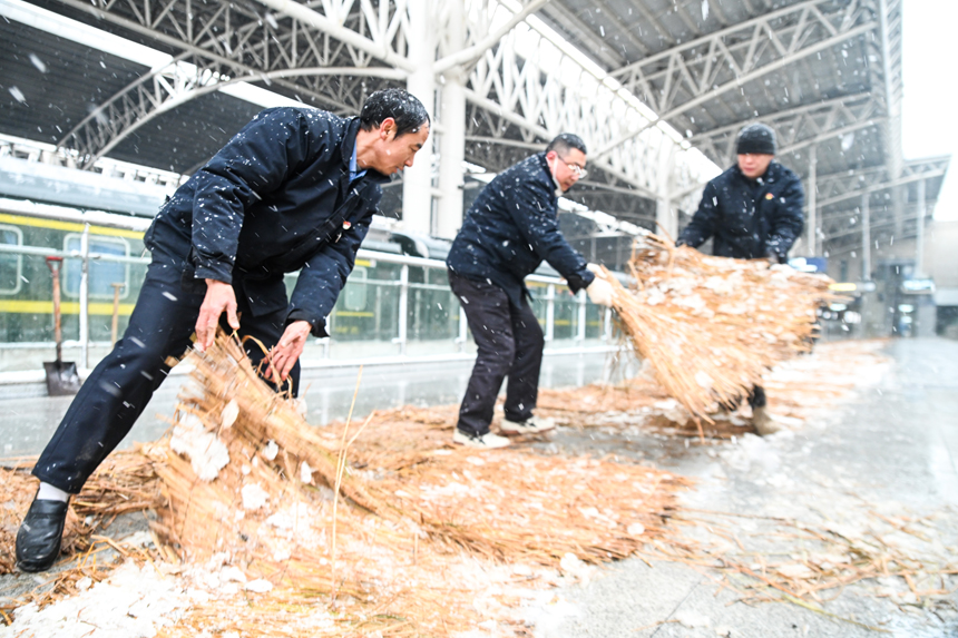 南昌站工作人员在站台上铺设防滑草垫。刘慕摄