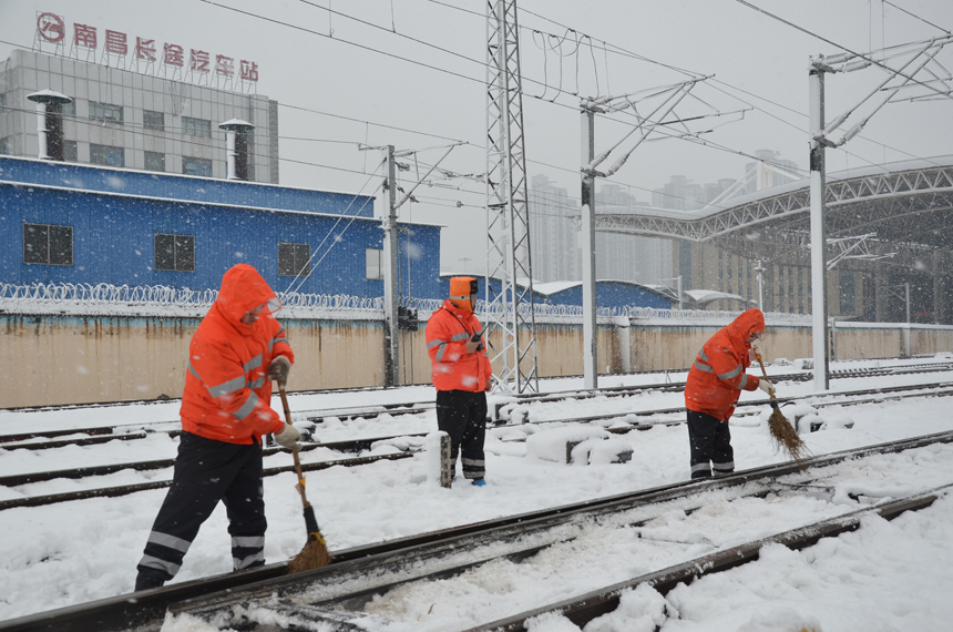 南昌站工作人员正在股道内清扫道岔积雪。刘慕摄