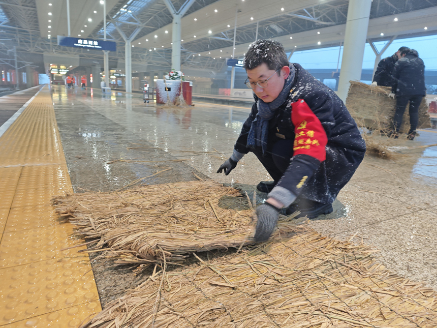 南昌西站工作人员在站台铺设草垫，保障旅客安全出行。 贺婷婷摄
