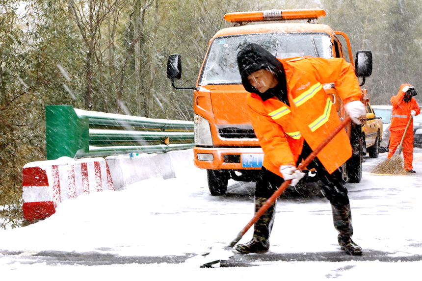 广昌县的公路养护工人在国道G528船顶隘至水南路段铲除积雪。丁健摄
