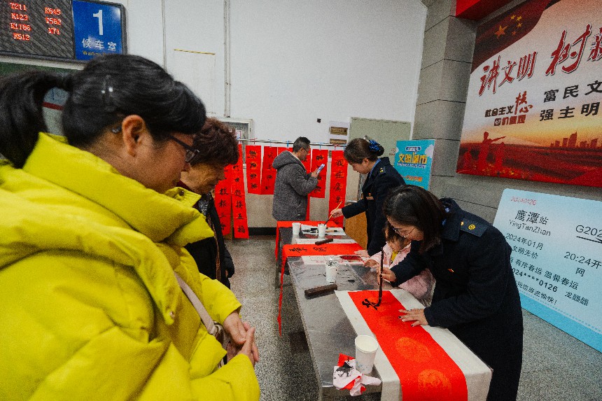旅客正在等待鷹潭站工作人員為自己寫春聯。肖鈺康攝