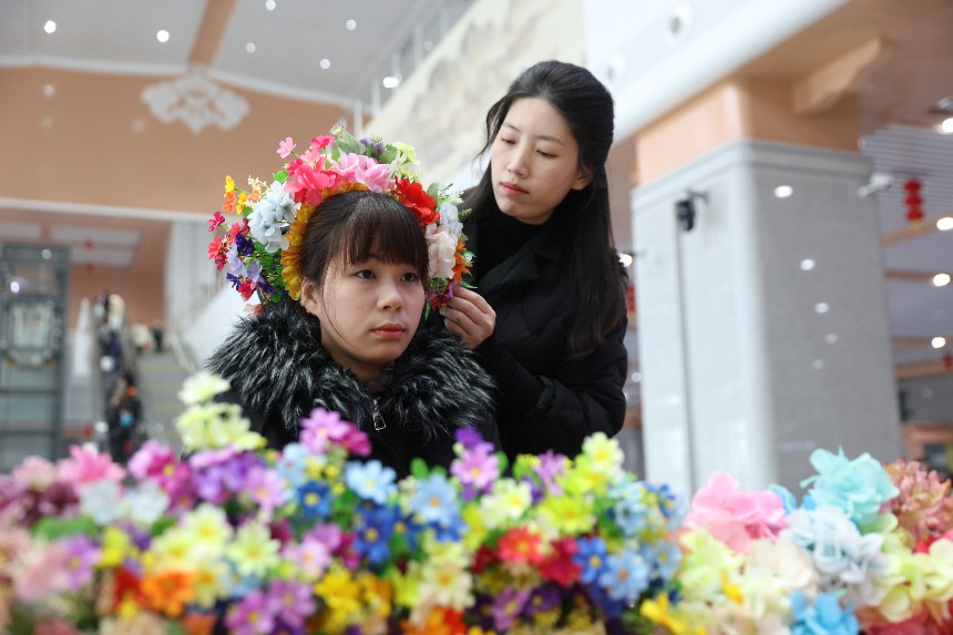 簪花圍老師現場為旅客簪上美麗的花朵。陳明攝