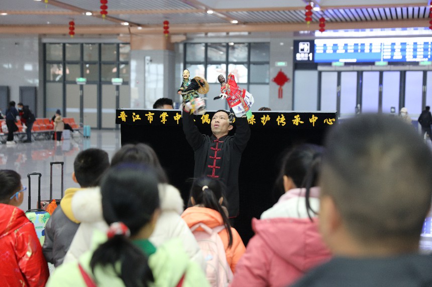 泉州南站候車室圍滿了觀看布袋木偶戲表演的旅客。陳明攝