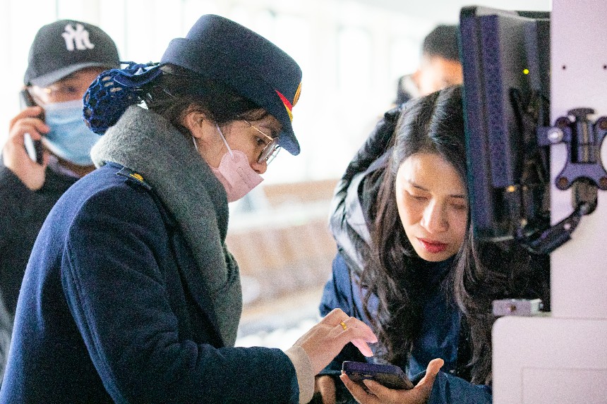 贛州西站工作人員正在幫助旅客查驗証件進站乘車。鄒陽攝