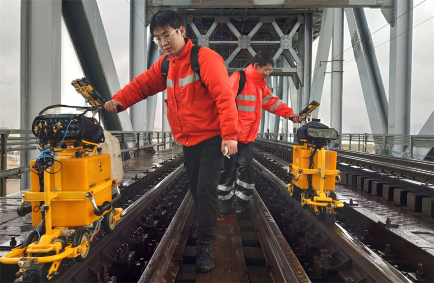 探伤工推行钢轨探伤仪行走在九江长江大桥上。刘连飞摄
