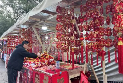 西湖區煙草局零售客戶張志斌在整理店門口的年貨擺攤。張帥攝